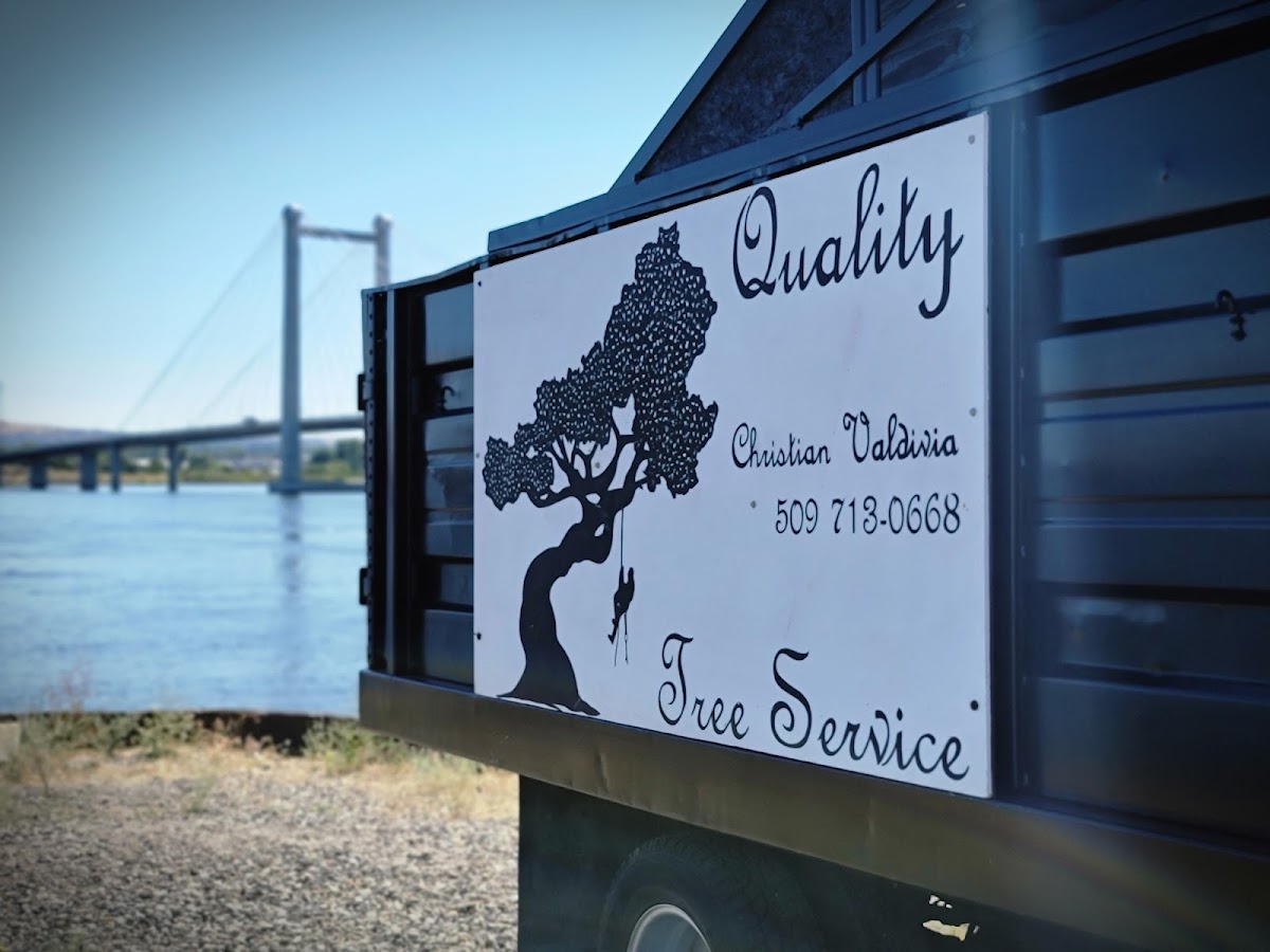 The Quality Tree Service logo sign by the Columbia River